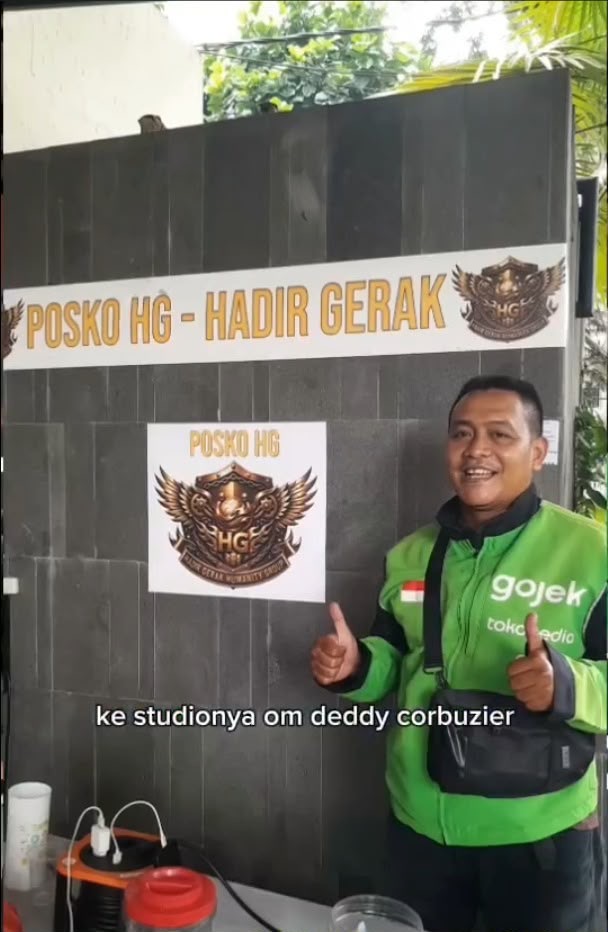 Pengemudi di depan papan Posko HG Hadir Gerak